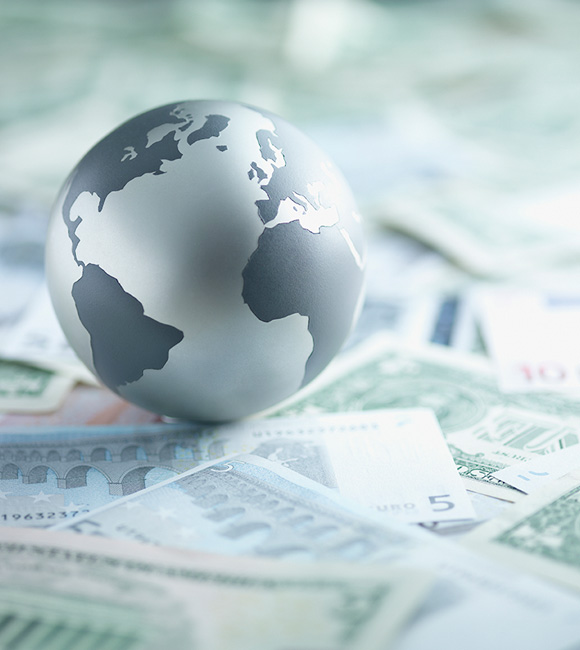 metal globe sitting on paper money
